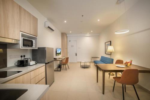 a kitchen and a living room with a table in a room at The Signature Serviced Suites Puchong in Puchong