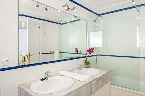 a bathroom with two sinks and a mirror at Bahia Blue - La Caleta in Adeje