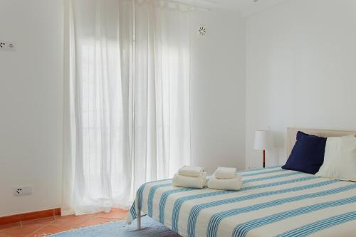 een slaapkamer met een bed met twee handdoeken erop bij Casa do Terreiro in Tavira