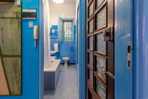 a blue bathroom with a tub and a toilet at Un tocco di Blu - La Vegra Apartment in Ferrara