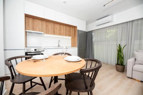 a kitchen and dining room with a wooden table and chairs at LASARI comfort living in Thessaloniki