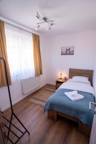 a bedroom with a bed with a blue blanket and a window at Apartman Niko in Livno