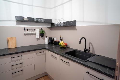 a kitchen with a sink and a black counter top at Apartman Niko in Livno