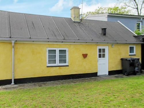 a yellow house with a black roof at 4 person holiday home in Asaa in Aså