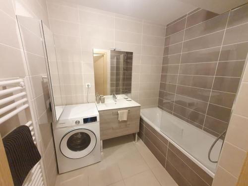 y baño blanco con lavadora. en Superbe appartement Evian, en Évian-les-Bains