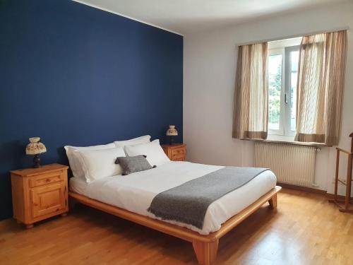 ein Schlafzimmer mit einem großen Bett mit blauer Wand in der Unterkunft Victoria Apartment by Quokka 360 - simple and practical flat in Locarno in Solduno
