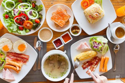 a table topped with plates of food and bowls of soup at Kacha Resort & Spa, Koh Chang - SHA Extra Plus in Ko Chang