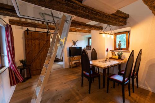 a dining room with a table and chairs and a ladder at Wohnen auf der Ritterburg in Haßmersheim