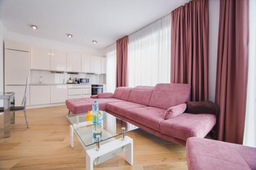 - un salon avec un canapé rose et une table dans l'établissement Pink Sahara near City Center, à Oradea