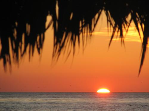 a sunset over the ocean with the sun in the horizon at The Shoal Hotel La Jolla Beach in San Diego