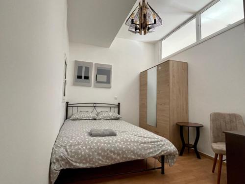 1 dormitorio con cama, mesa y lámpara de araña en 4-bedroom Family apartment in the center of Athens, en Atenas