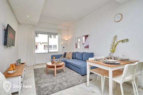 a living room with a blue couch and a table at Stayhere Rabat - Agdal 2 - Classic Residence in Rabat