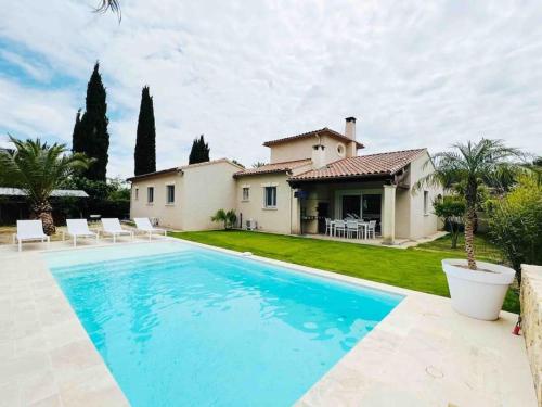 une piscine devant une maison dans l'établissement Belle villa typique du sud avec grande piscine, à Assas