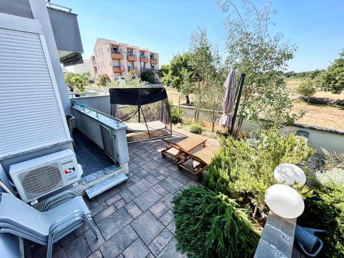 a patio with a table and chairs and a heater at APARTMENT SECRET GARDEN 3 in Zaton