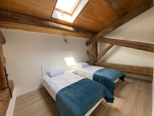 2 łóżka w pokoju na poddaszu z drewnianymi sufitami w obiekcie T4 bord canal du midi, piscine w mieście Homps