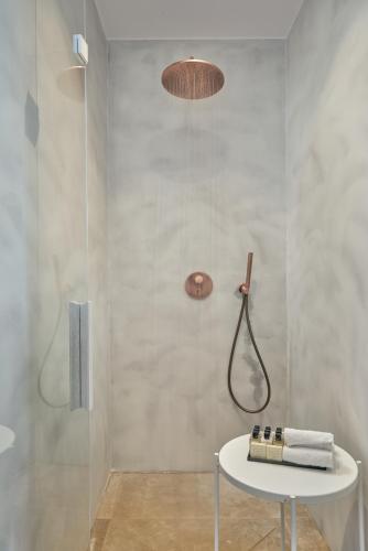 a bathroom with a shower and a white table at Once in Mykonos - Designed for Adults in Ornos