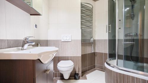 uma casa de banho com um WC, um lavatório e um chuveiro em Apartamenty Sun & Snow Morskie Oko em Międzyzdroje