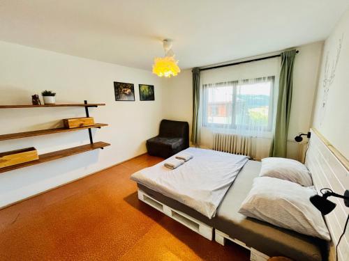 ein Schlafzimmer mit einem Bett und einem Stuhl darin in der Unterkunft Horská chata NATURA Nové Město in Nové Město