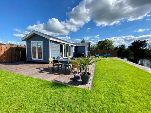 a tiny house with a table and chairs on a deck at New - Waterfont Villa08 - Private Residence on a lake near Amsterdam in Vinkeveen