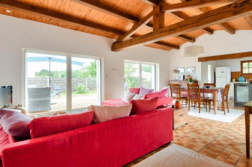 un salon avec un canapé rouge et une cuisine dans l'établissement Maison pour 7 - 400 m de la plage de la Clère, à Noirmoutier-en-l'lle
