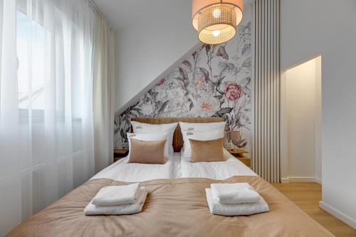 sypialnia z dużym łóżkiem z dwoma ręcznikami w obiekcie Waterlane Vintage - Fitness & Parking by Downtown Apartments w Gdańsku