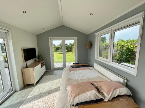 1 dormitorio con 1 cama y 2 ventanas en New - Waterfont Villa08 - Private Residence on a lake near Amsterdam en Vinkeveen