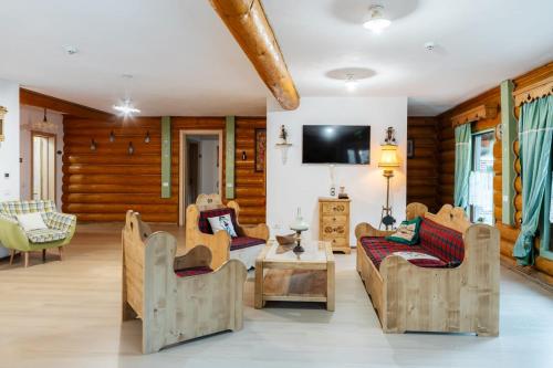 a living room filled with furniture and a flat screen tv at Cabana Bavareză in Porumbacu de Sus