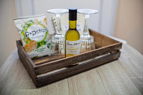 a wooden tray with glasses and a bottle of wine at Y Villa Môr in Llanarth