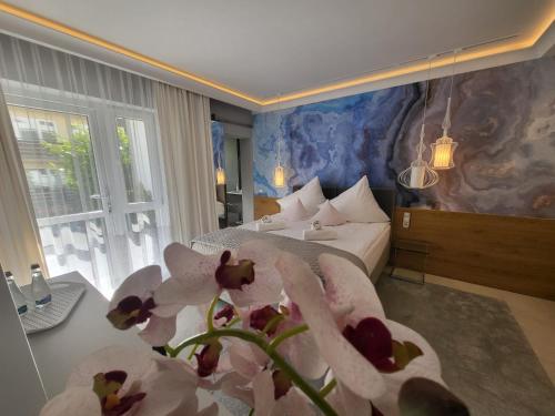 ヤストシェンビャ・グラにあるDom Wypoczynkowy Oskarのベッドと花のテーブルが備わるホテルルームです。