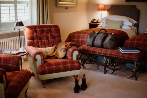 a hotel room with a bed and a chair and a bed at Links House at Royal Dornoch in Dornoch