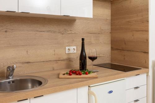 eine Küchentheke mit einer Flasche Wein und einem Glas in der Unterkunft Apartment Tihi in Vodice