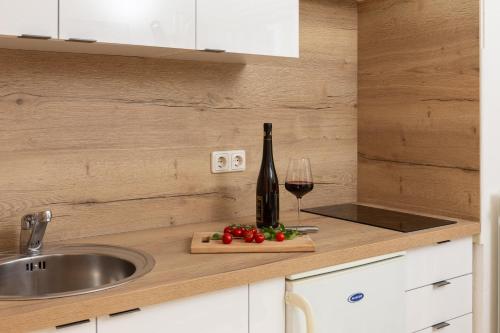 a kitchen counter with a bottle of wine and a glass at Seaview Apartments Tihi in Vodice