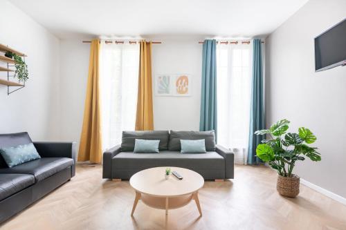 un salon avec un canapé et une table dans l'établissement Nets Inn Apartments - Daumesnil, à Paris