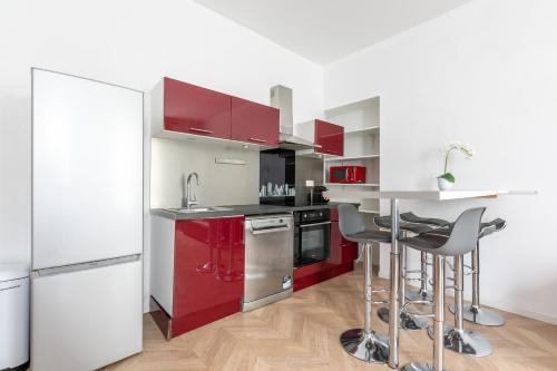 une cuisine avec des armoires rouges et un réfrigérateur blanc dans l'établissement Nets Inn Apartments - Daumesnil, à Paris
