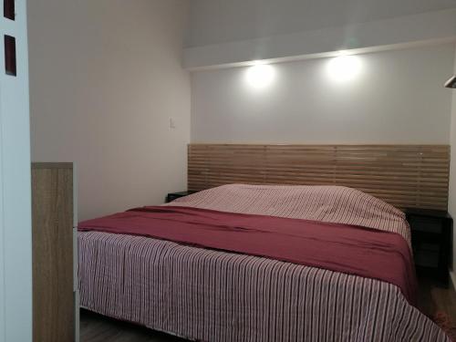 um quarto com uma cama grande e uma cabeceira em madeira em Coeur de ville Appartement t3 pour 6 personnes N1 7 em La Grande-Motte