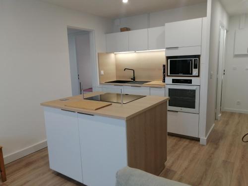 uma cozinha com armários brancos e uma bancada em Coeur de ville Appartement t3 pour 6 personnes N1 7 em La Grande-Motte