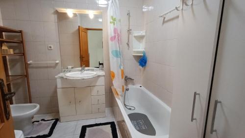 uma casa de banho com um lavatório, uma banheira e um WC. em Palmeiras em Arcozelo