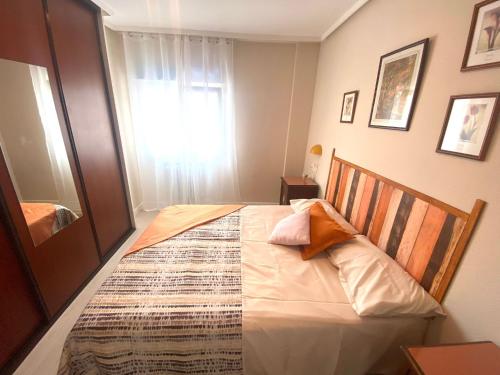 - une chambre avec un grand lit et une fenêtre dans l'établissement Apartamento Centro Gijón Los Patos, à Gijón