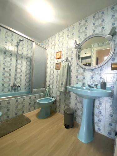 a bathroom with a sink and a toilet and a mirror at Apartamento Centro Gijón Los Patos in Gijón