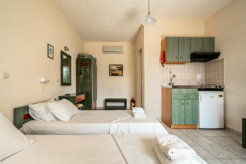 two beds in a small room with a kitchen at Anemona studio B in Katelios