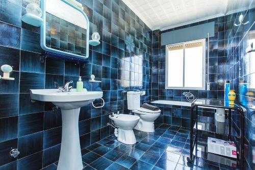 uma casa de banho em azulejos azuis com um lavatório e um WC em 250 Finca CODOVI - Alicante Holiday em Los Montesinos