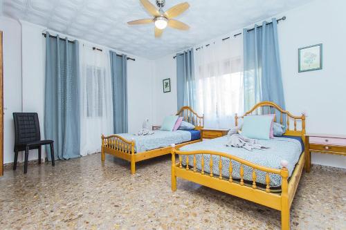 um quarto com 2 camas e uma ventoinha de tecto em 250 Finca CODOVI - Alicante Holiday em Los Montesinos