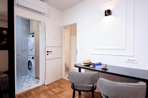 eine Küche mit einem Tisch und Stühlen sowie einer Waschmaschine in der Unterkunft Studio apartment Fingerprint in Hvar