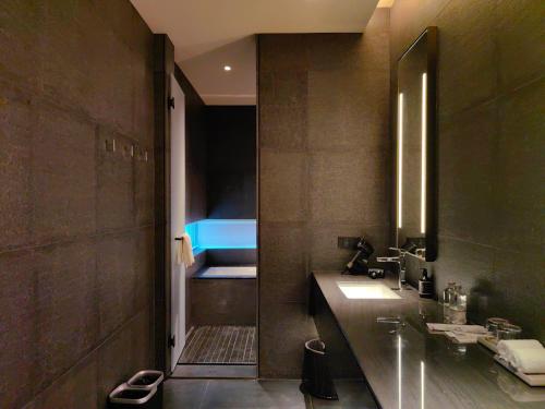 a bathroom with a sink and a bed in it at Jiangnan House Chaozhou in Chaozhou