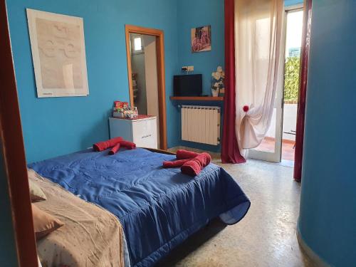 a blue bedroom with a bed with red pillows on it at La capannina cilento cam 10 in San Marco di Castellabate