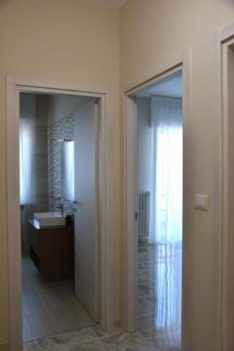 a bathroom with a mirror and a sink and a mirror at Russo Apartment in Termoli
