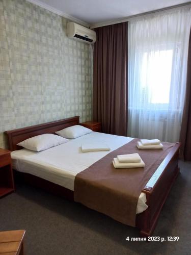 a bedroom with a large bed with two towels on it at Hotel LaMa 2 in Kyiv