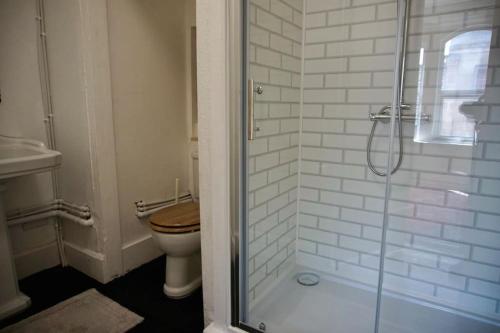 ein Bad mit einem WC und einer Glasdusche in der Unterkunft The Hideout - Top of the Town - Apartment in Stroud in Stroud