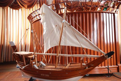 a wooden boat on display in a room at The Raviz Kadavu, Kozhikode in Kozhikode