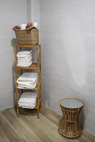 a towel rack with towels and a basket and a chair at Casas rurales La Carrasca in Ossa de Montiel